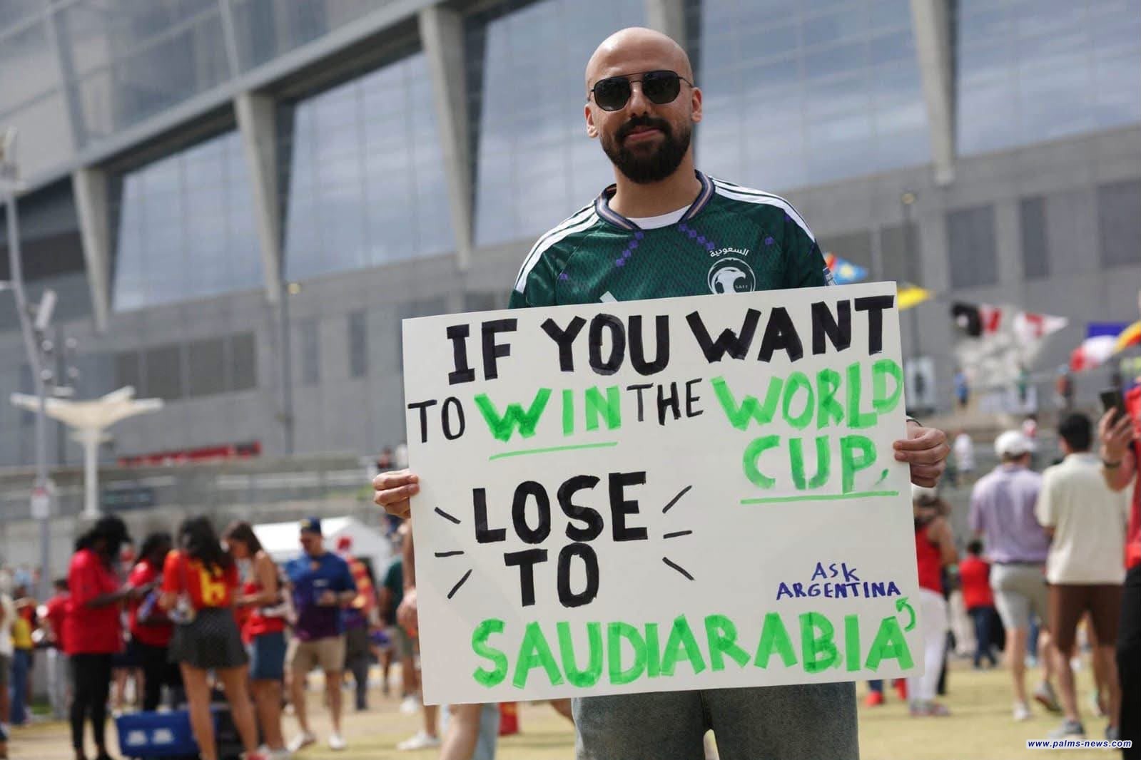 مشجع سعودي يرفع  لافتة مكتوب عليها "إذا كنت تريد الفوز بكأس العالم فعليك أن تخسر أمام السعودية"